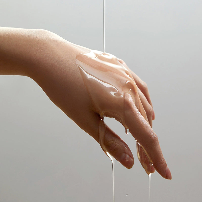 Aceite transparente del limpiador Anua Heartleaf escurriéndose sobre una mano, mostrando su consistencia fluida y acabado no graso.