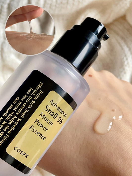 Botella de COSRX Advanced Snail 96 Mucin Power Essence dispensando esencia transparente sobre la mano, con un recuadro que muestra su textura viscosa entre los dedos.