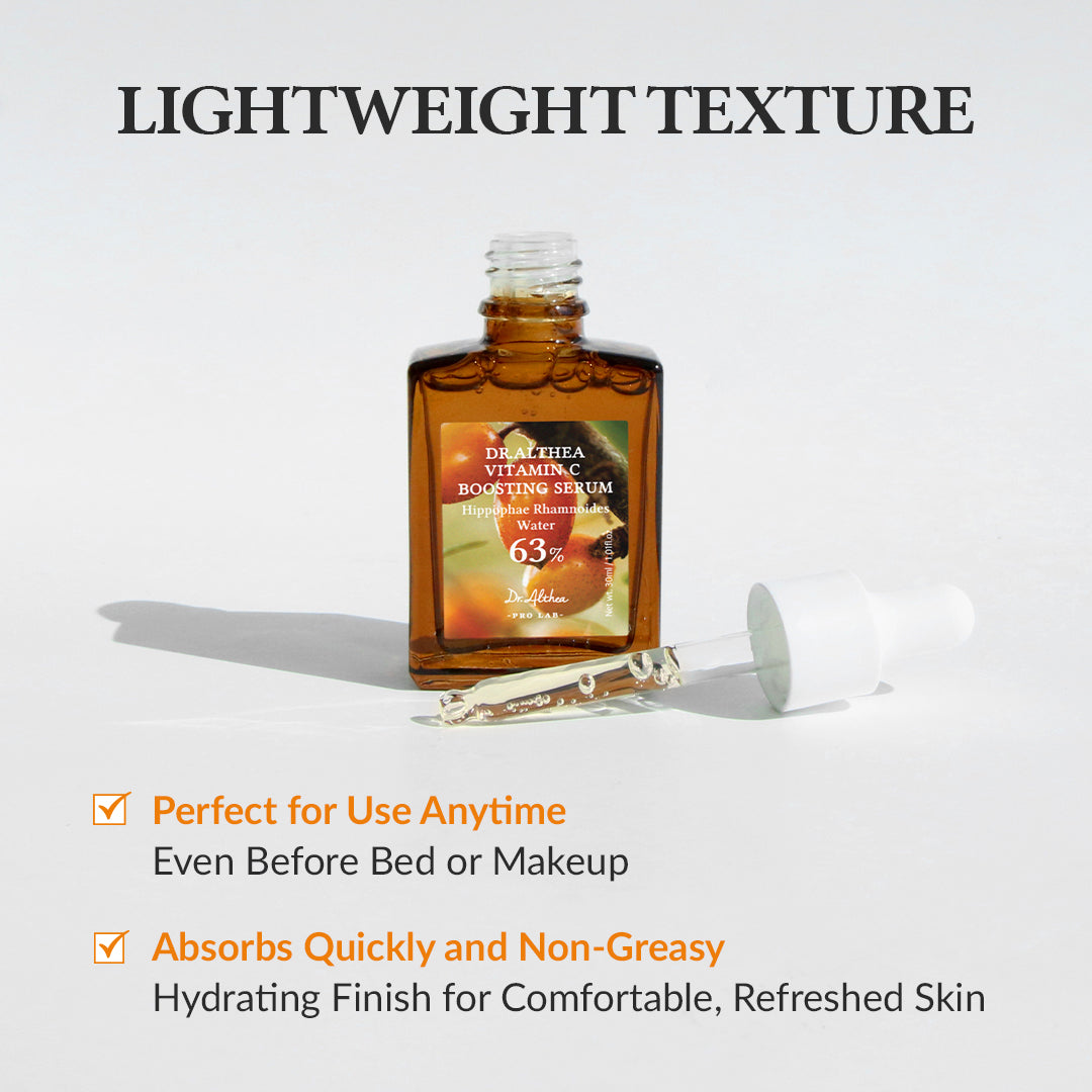 Frasco ámbar del Dr. Althea Vitamin C Boosting Serum con gotero blanco apoyado al lado y gotas de serum sobre una superficie clara bajo luz directa.