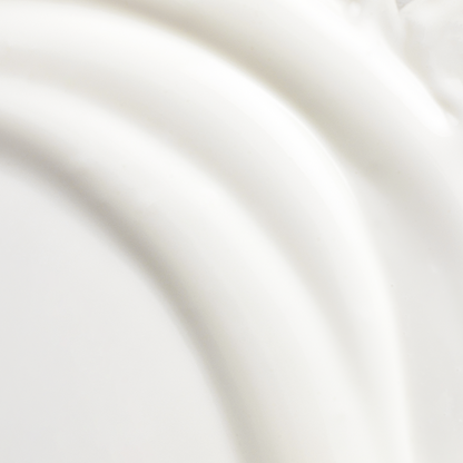 Textura blanca cremosa del protector solar House of Hur extendida en ondas suaves, mostrando consistencia ligera y sedosa.